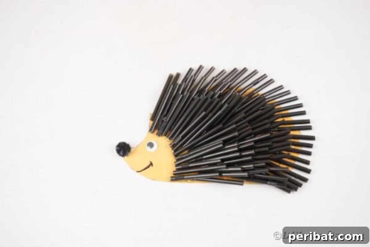 A completed black straw hedgehog craft displayed on a white table, showcasing its unique texture and adorable face.