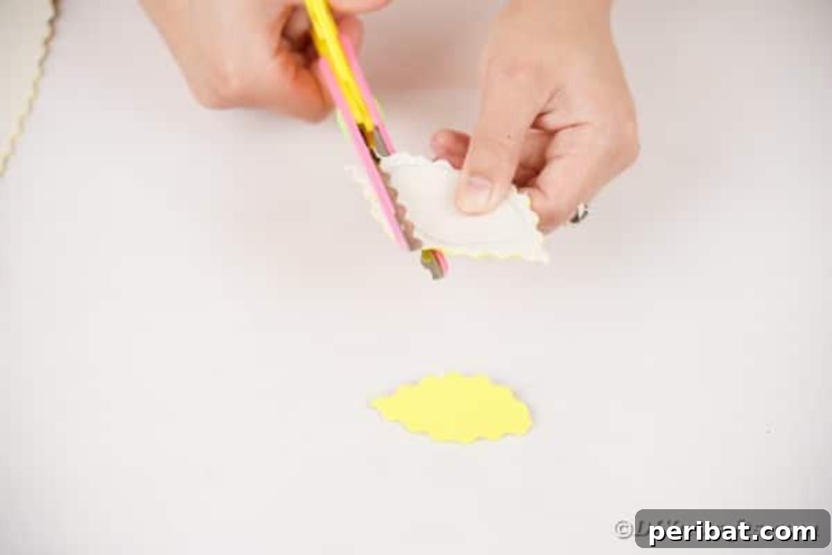 A hand using pinking shears to cut out a leaf shape from foam paper, showing the distinct zig-zag edge.