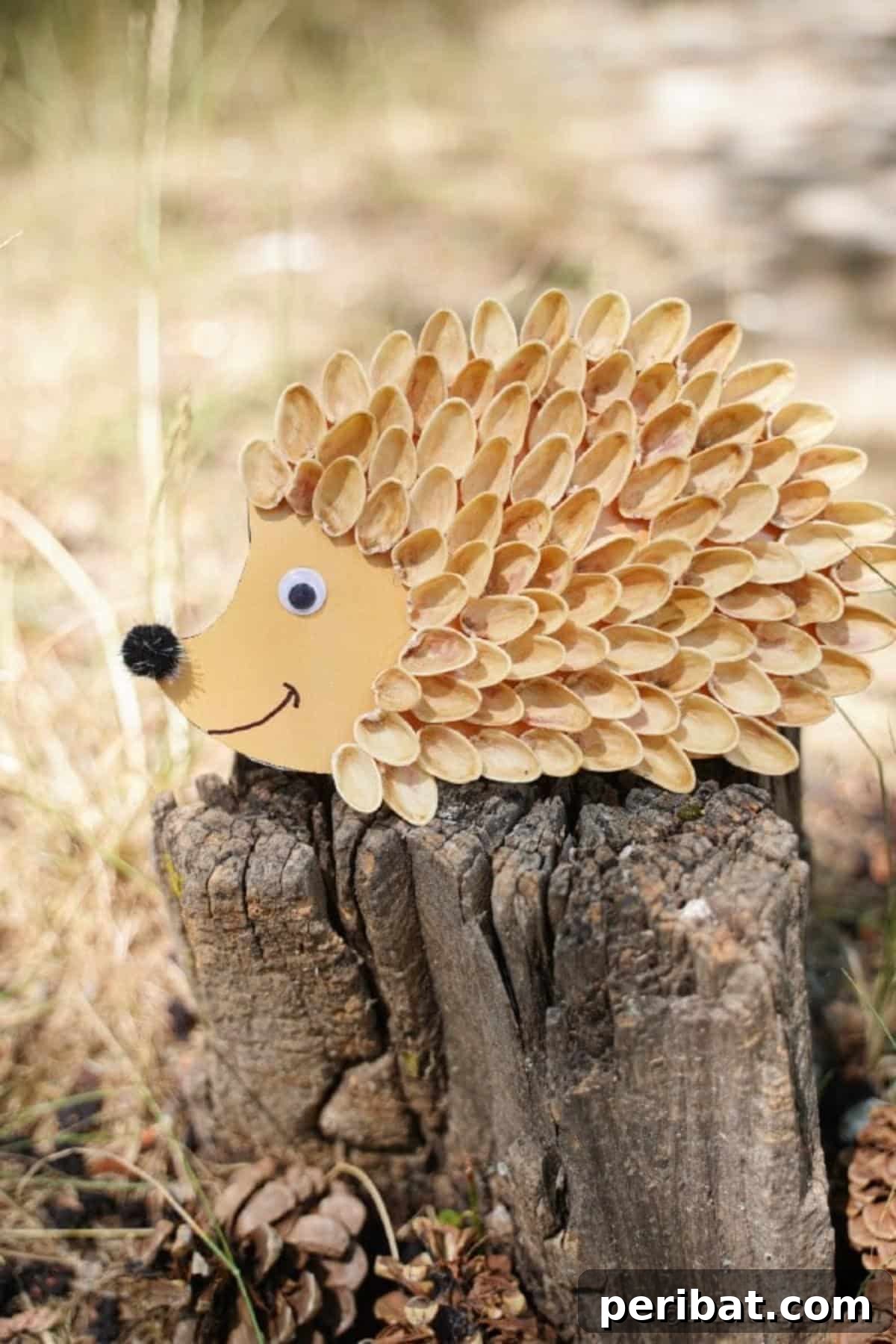 A pistachio shell hedgehog craft displayed on a tree stump in an outdoor setting, blending with natural elements.