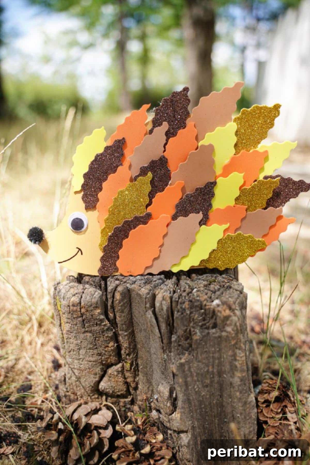 A paper leaf hedgehog craft positioned on a tree stump in a natural outdoor environment, showcasing its autumnal colors.