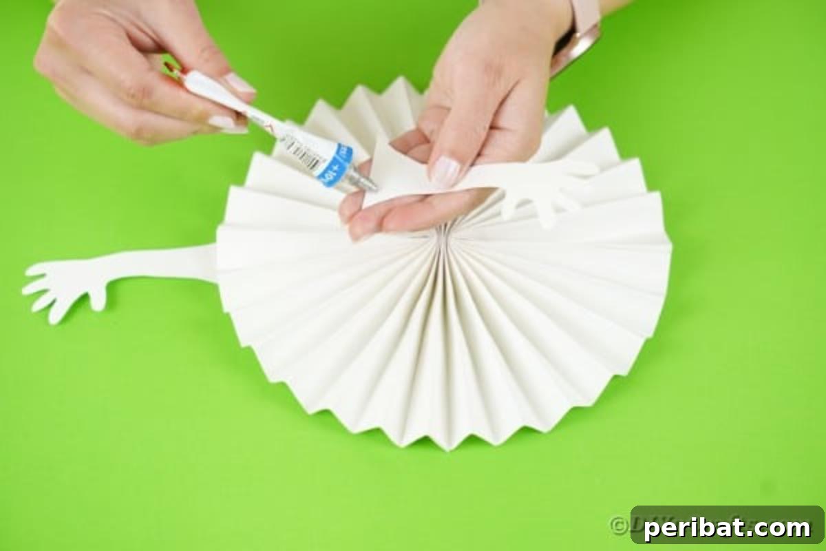 Fun and Easy Halloween Paper Fan Decor 16 Gluing arms onto white ghost paper
