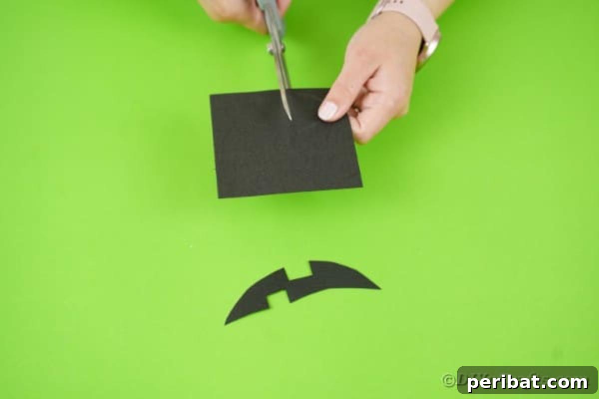 Fun and Easy Halloween Paper Fan Decor 22 Cutting face pieces out of black paper