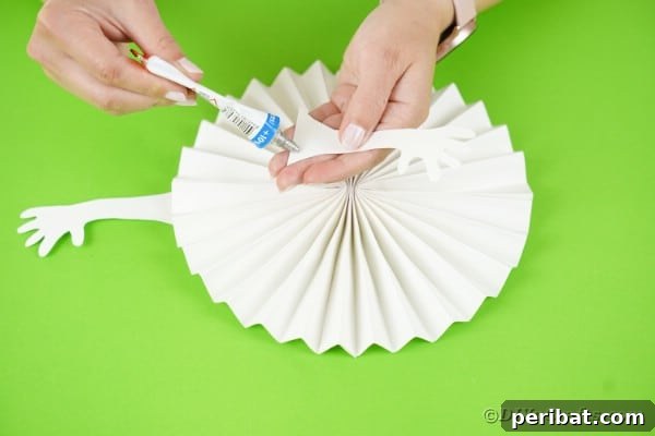 Fun and Easy Halloween Paper Fan Decor 33 Gluing arms onto white ghost paper