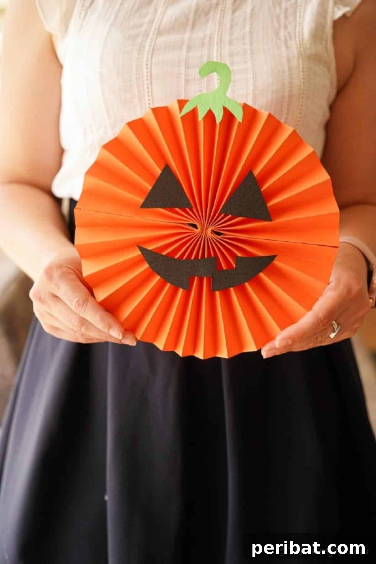 Fun and Easy Halloween Paper Fan Decor 41 Woman holding paper fan pumpkin