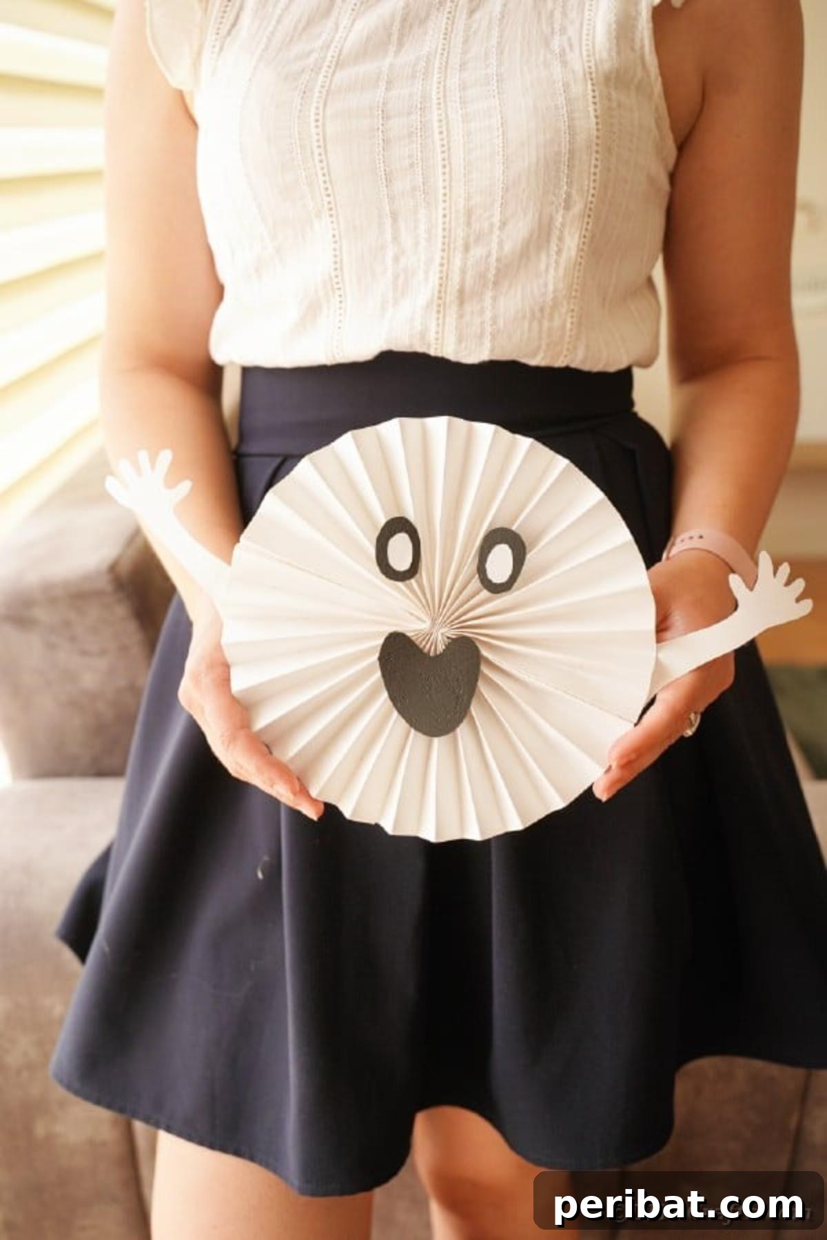 Fun and Easy Halloween Paper Fan Decor 42 Woman holding paper ghost decoration