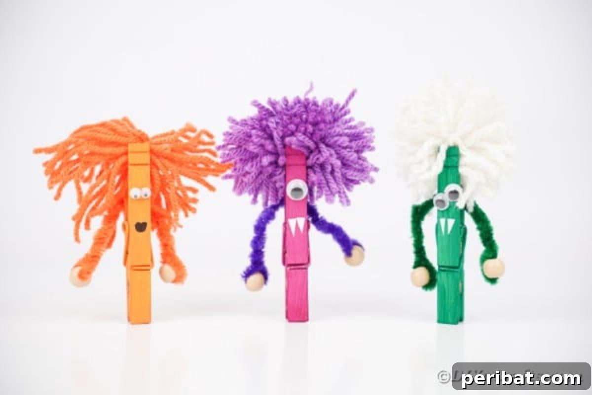 Spooktacular Clothespin Monster Craft 5 Close-up of three completed clothespin monsters on a white surface