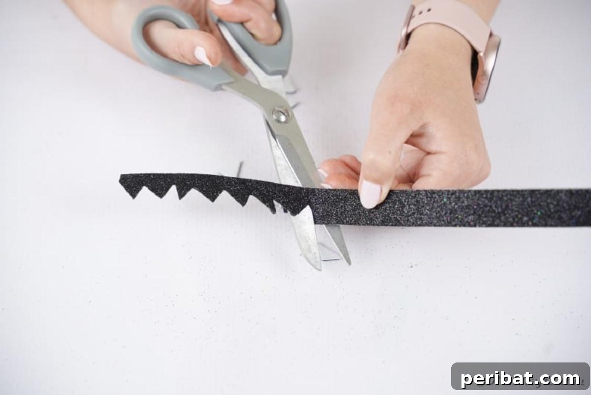 Charming Upcycled Planter Halloween Pals 16 Cutting a strip of black foam paper with jagged notches to create Frankenstein's hair.