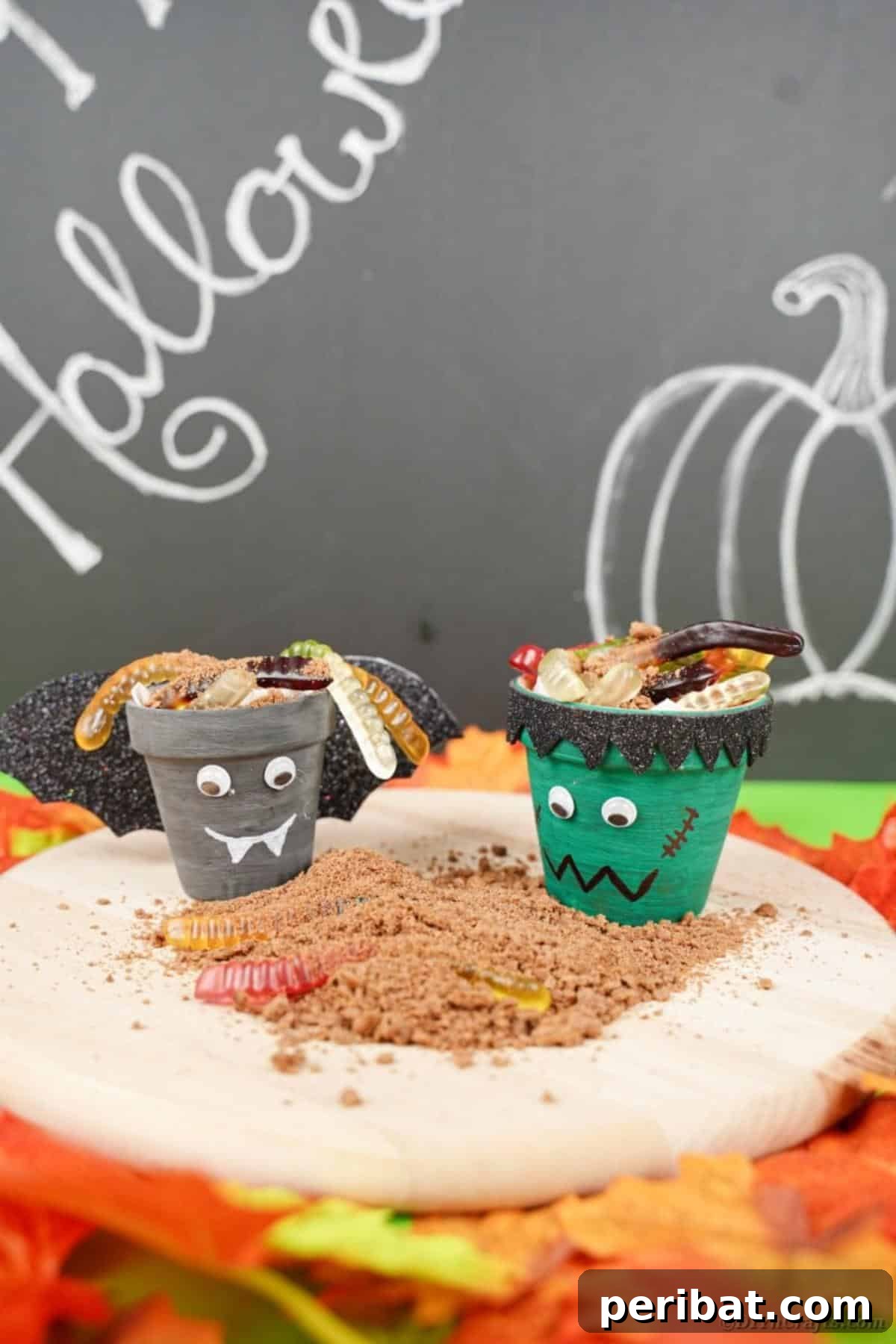 Charming Upcycled Planter Halloween Pals 20 Two finished Halloween flower pots, a bat and Frankenstein, filled with treats and displayed on a bed of fake sand.