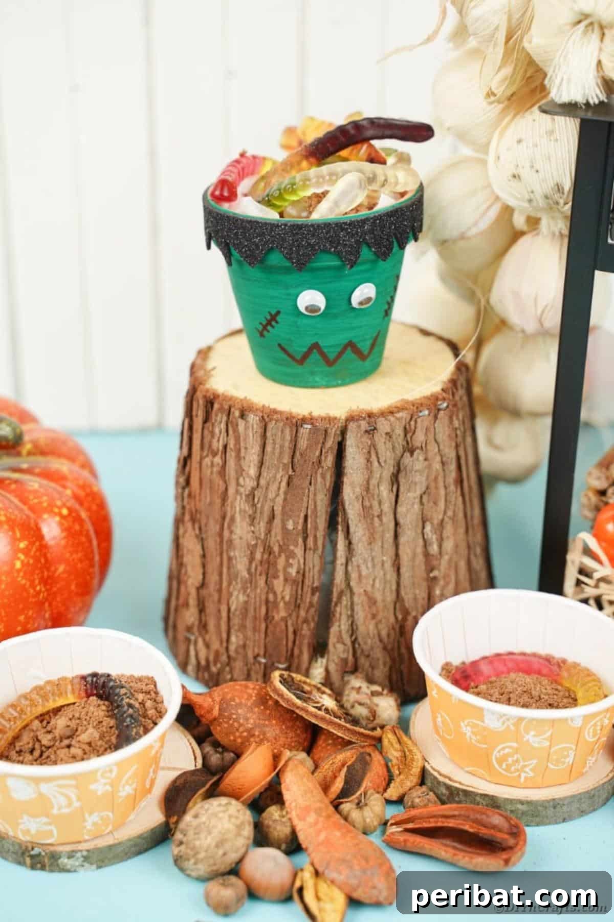 Charming Upcycled Planter Halloween Pals 22 An upcycled flower pot Frankenstein character with googly eyes and stitches, displayed on a tree stump.