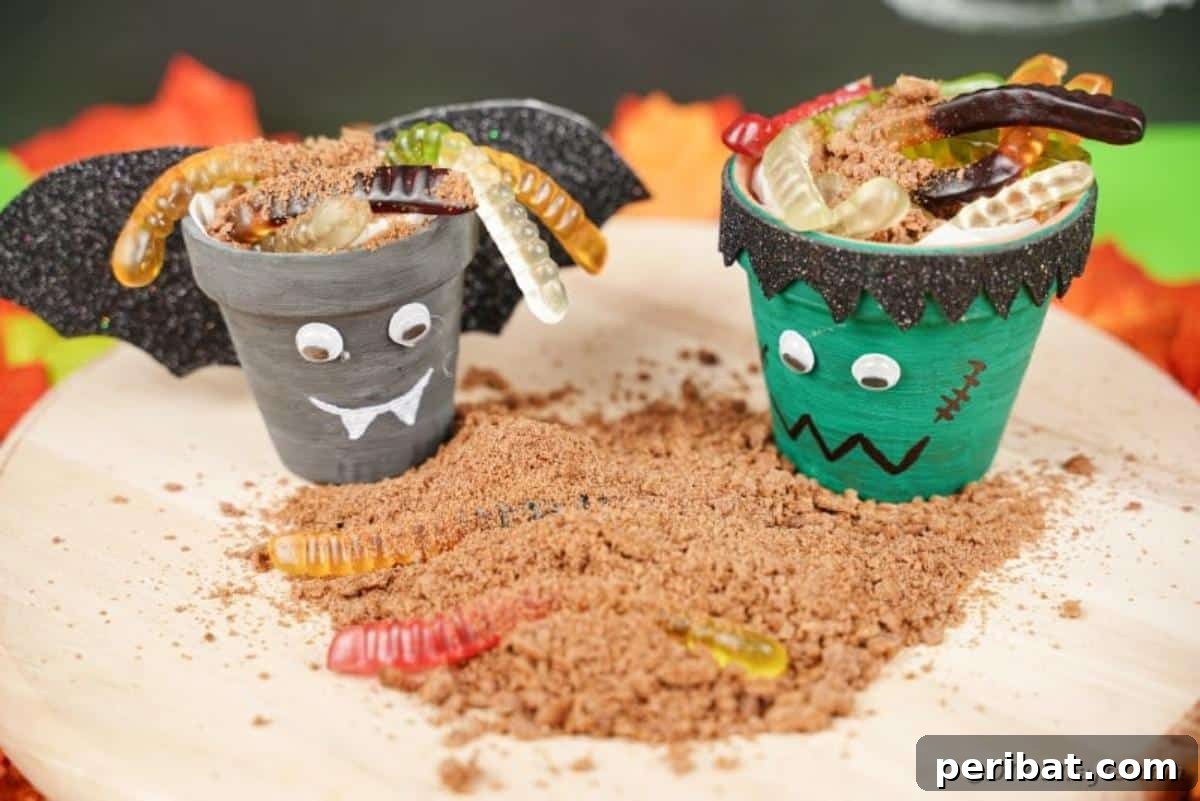 Charming Upcycled Planter Halloween Pals 6 Two completed flower pot Halloween characters, a bat and Frankenstein, placed on fake sand.