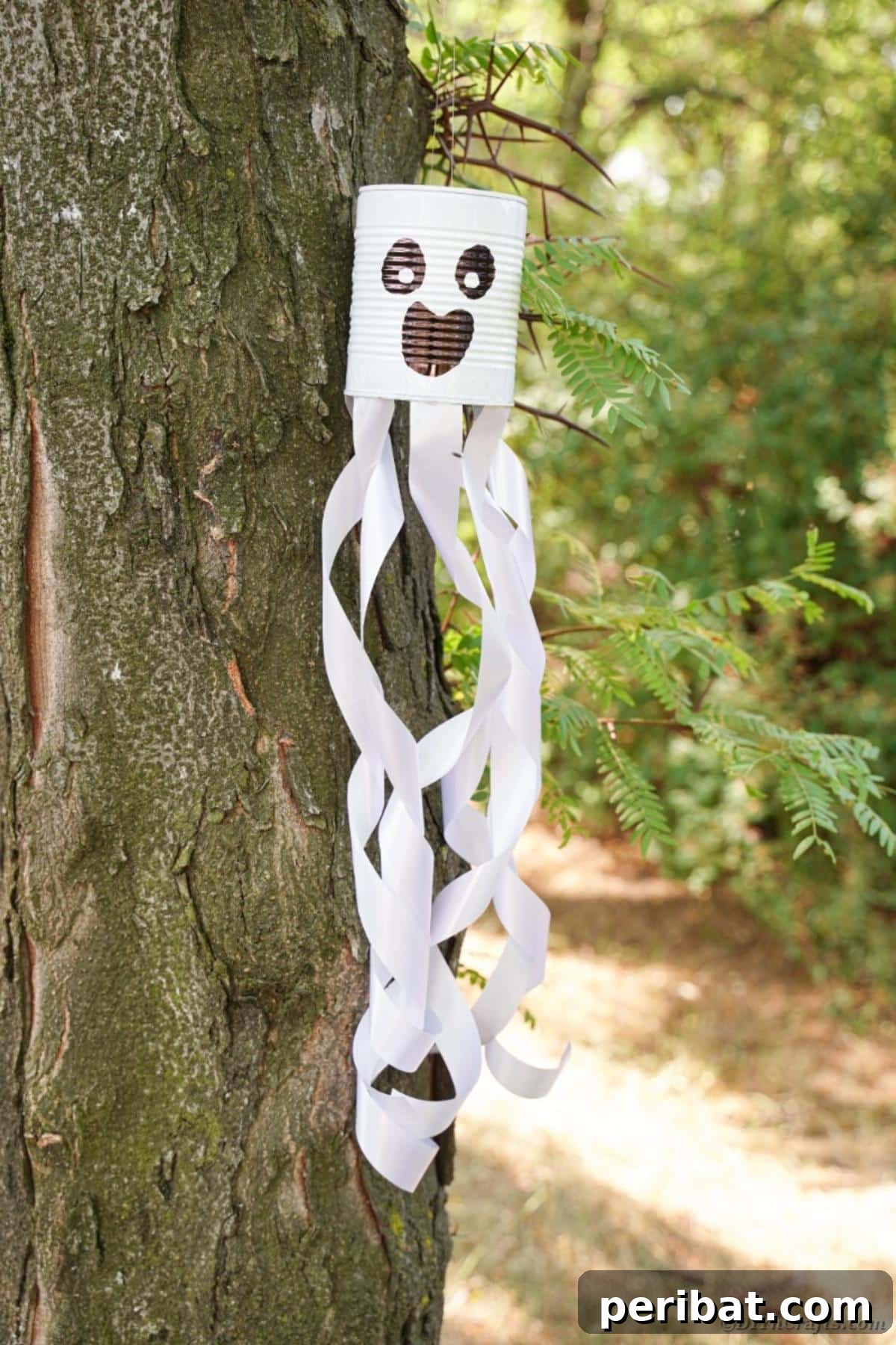 Haunting Tin Can Ghost Ornament 15 A beautifully finished tin can ghost hanging from a tree branch, ready to adorn your Halloween display.