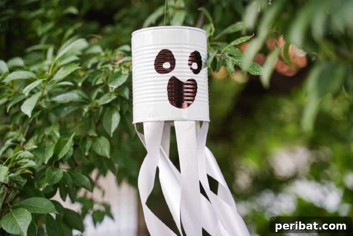 Haunting Tin Can Ghost Ornament 4 Another view of the DIY tin can ghost hanging elegantly from a tree branch, showing its streamers flowing in the gentle breeze.