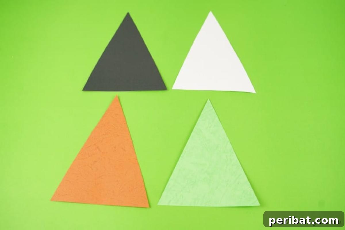 Colorful triangle craft paper flags laid out on a green table, ready for decoration
