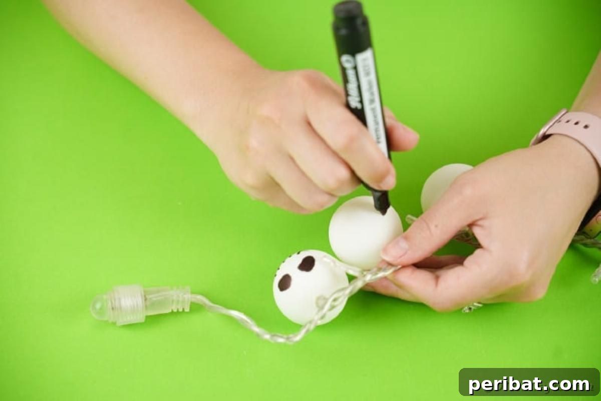 DIY Jack Skellington Halloween Garland with Ping Pong Balls 11 Drawing face on ping pong ball