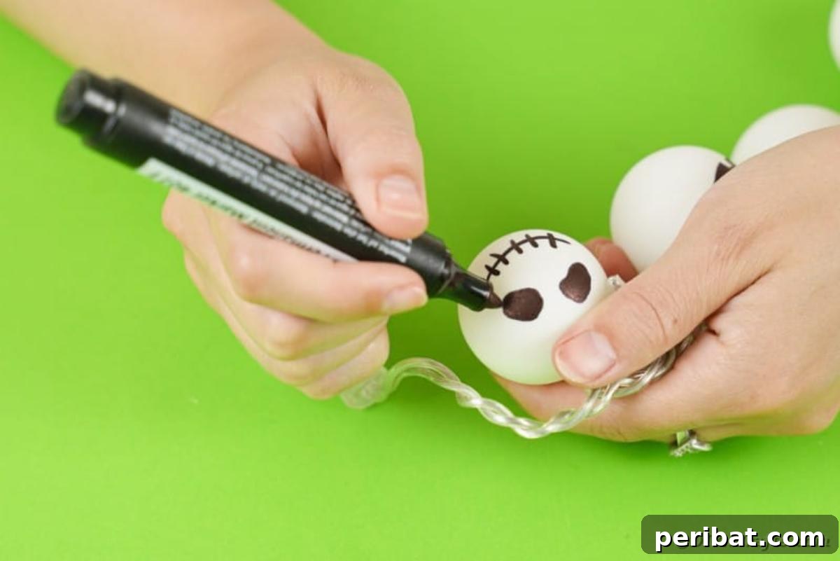 DIY Jack Skellington Halloween Garland with Ping Pong Balls 12 Drawing face on ping pong ball
