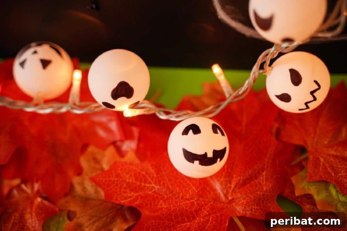 DIY Jack Skellington Halloween Garland with Ping Pong Balls 3 Twinkle light garland on fall leaves