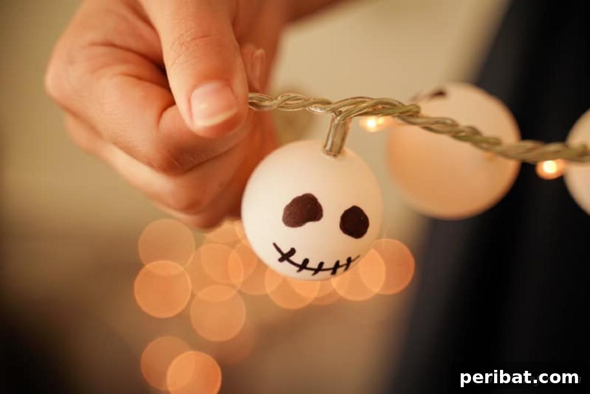 DIY Jack Skellington Halloween Garland with Ping Pong Balls 5 Woman holding Jack Skellington garland