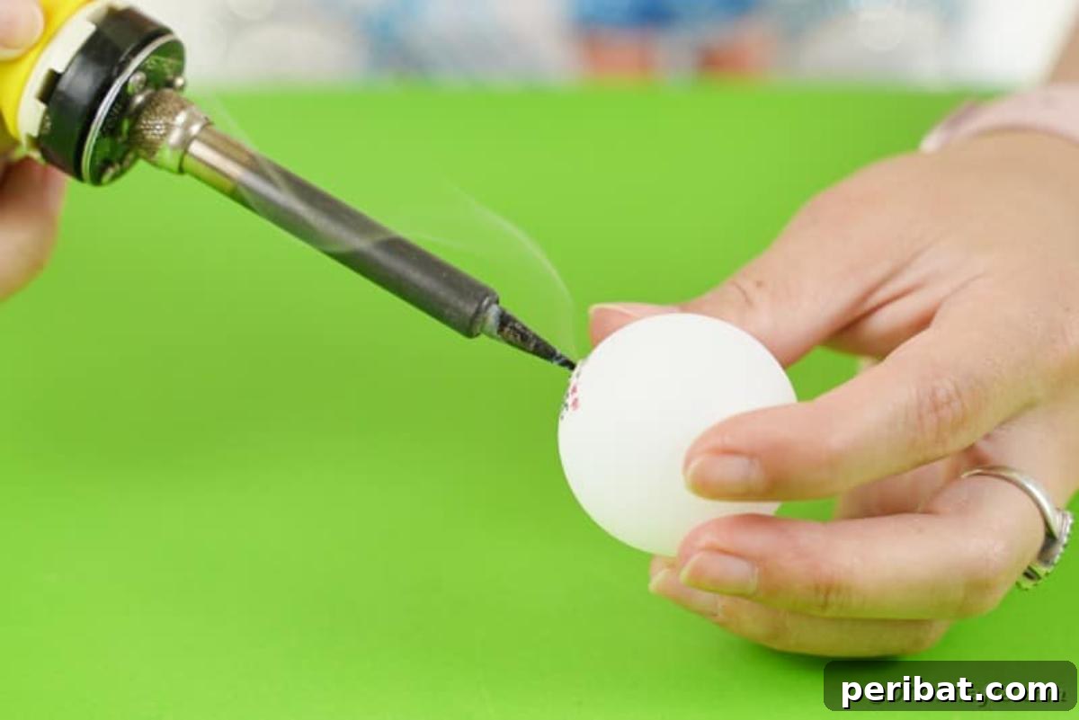 DIY Jack Skellington Halloween Garland with Ping Pong Balls 9 Cutting hole in ping pong ball