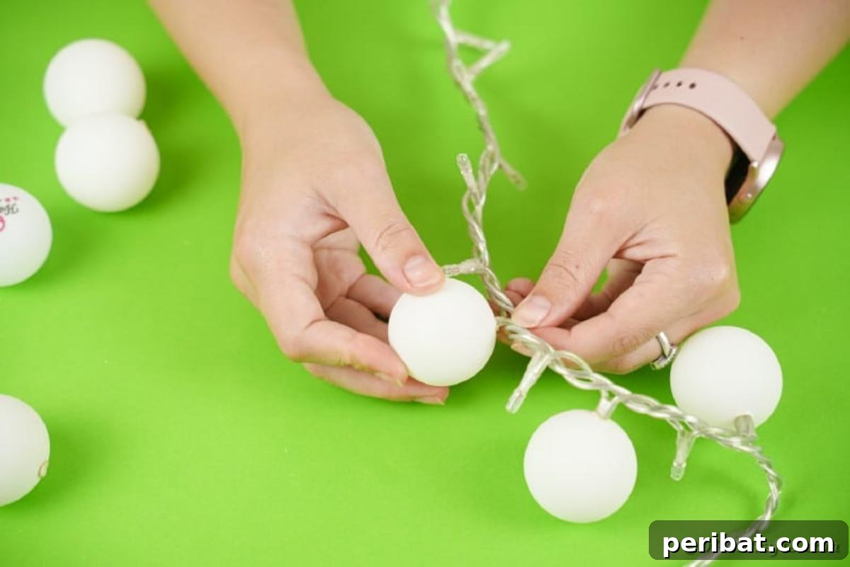DIY Jack Skellington Halloween Garland with Ping Pong Balls 10 Adding ping pong balls to lights