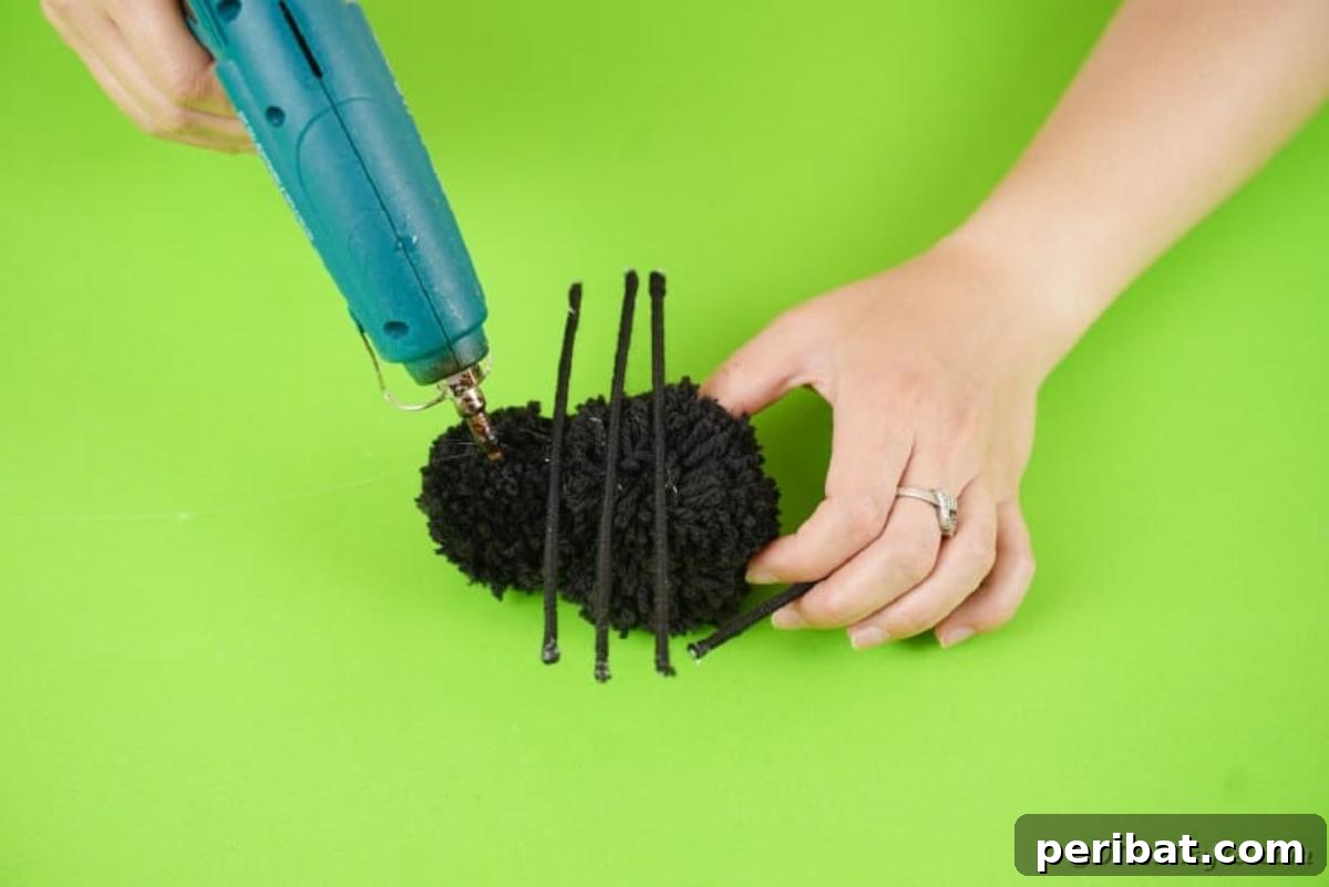 Gluing legs onto pom poms