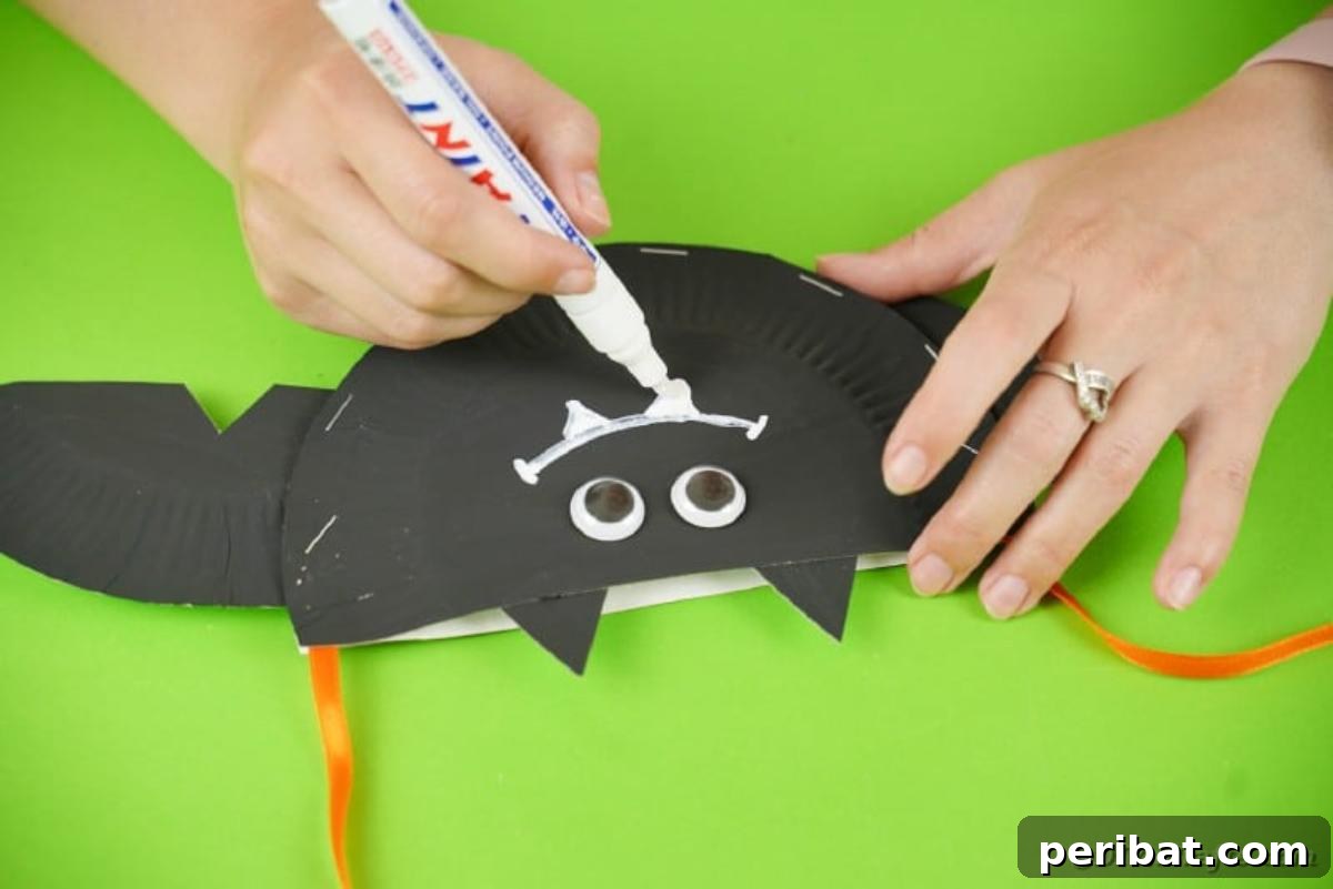 DIY Paper Plate Bat Candy Catchall 20 Drawing a smile on the bat face