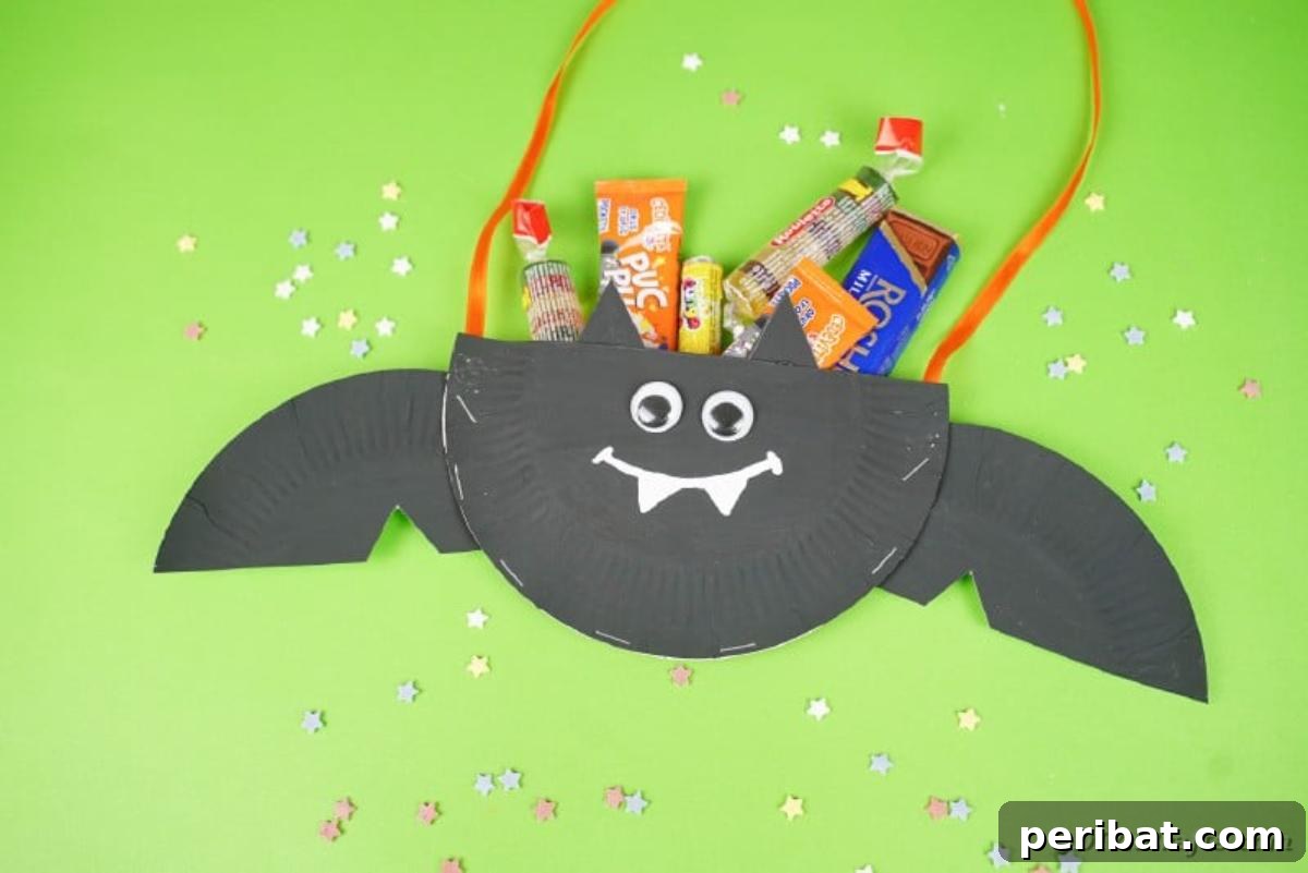 DIY Paper Plate Bat Candy Catchall 7 Paper plate bat on green surface filled with candy