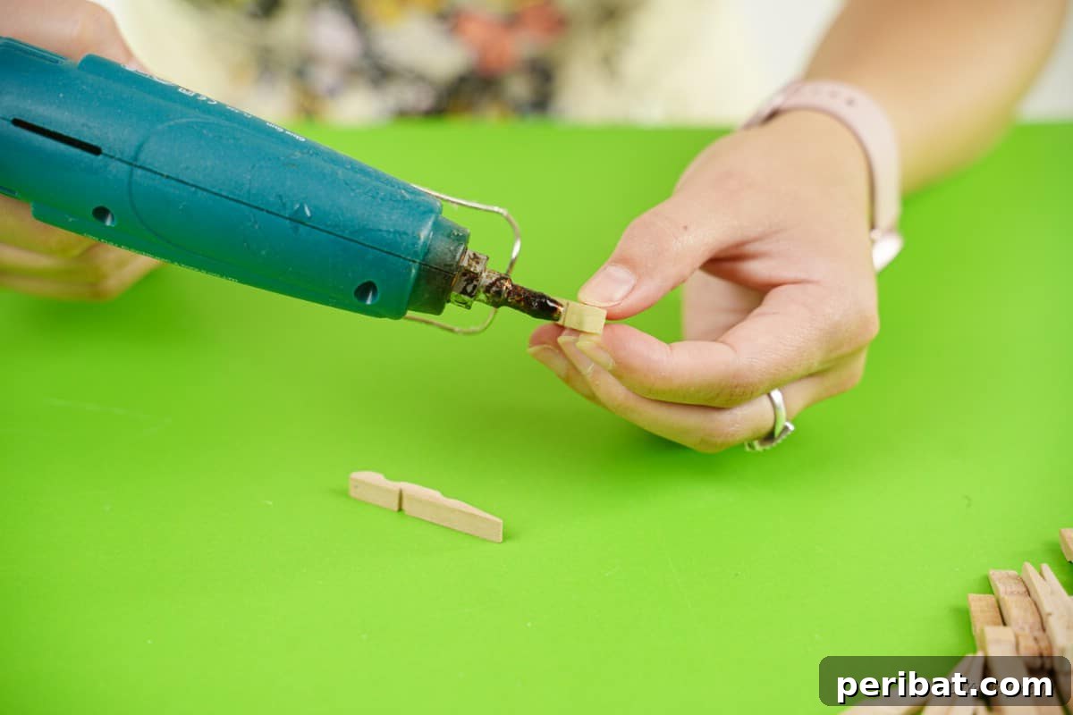 hot glue gun in woman's hand with clothespin