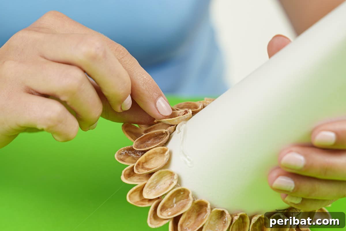 DIY Mini Christmas Trees from Upcycled Pistachio Shells 11 Arranging pistachio shells on a cone craft base