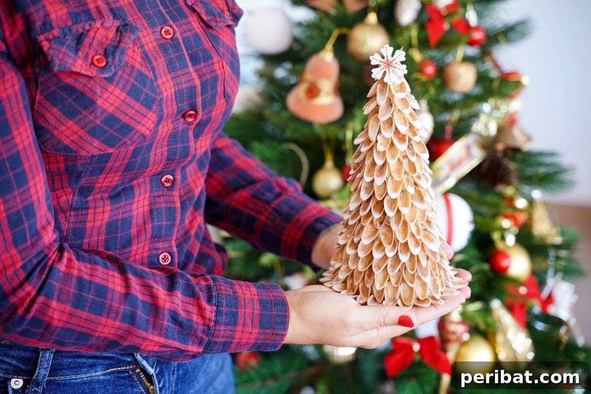 DIY Mini Christmas Trees from Upcycled Pistachio Shells 3 Person holding a handmade pistachio shell Christmas tree craft decoration