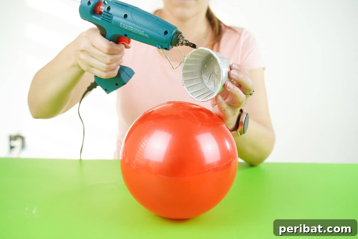 Applying superglue to a bowl for Christmas craft assembly