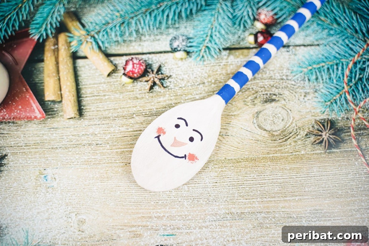 Snowman character painted craft wood spoon on table 