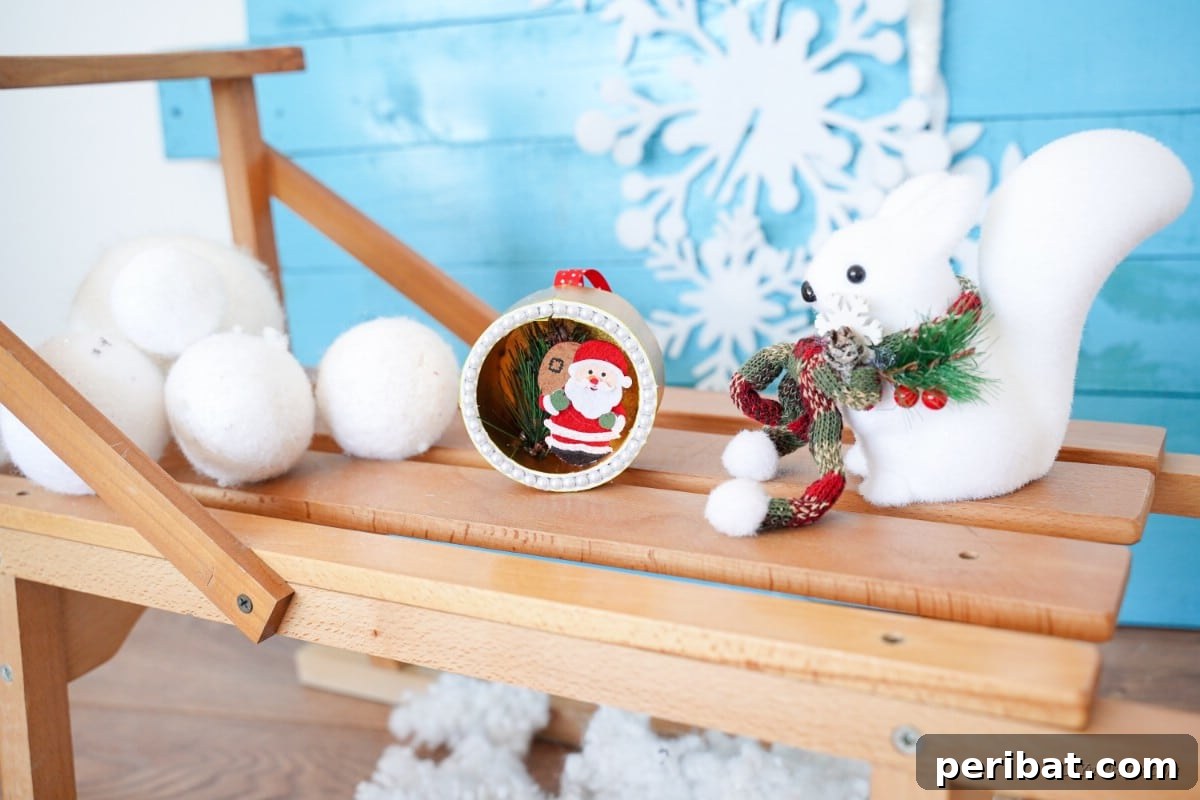 Whimsical Upcycled Santa 3D Christmas Tree Ornament 28 Santa themed upcycled craft sitting on a table with snowflakes, ready for display.
