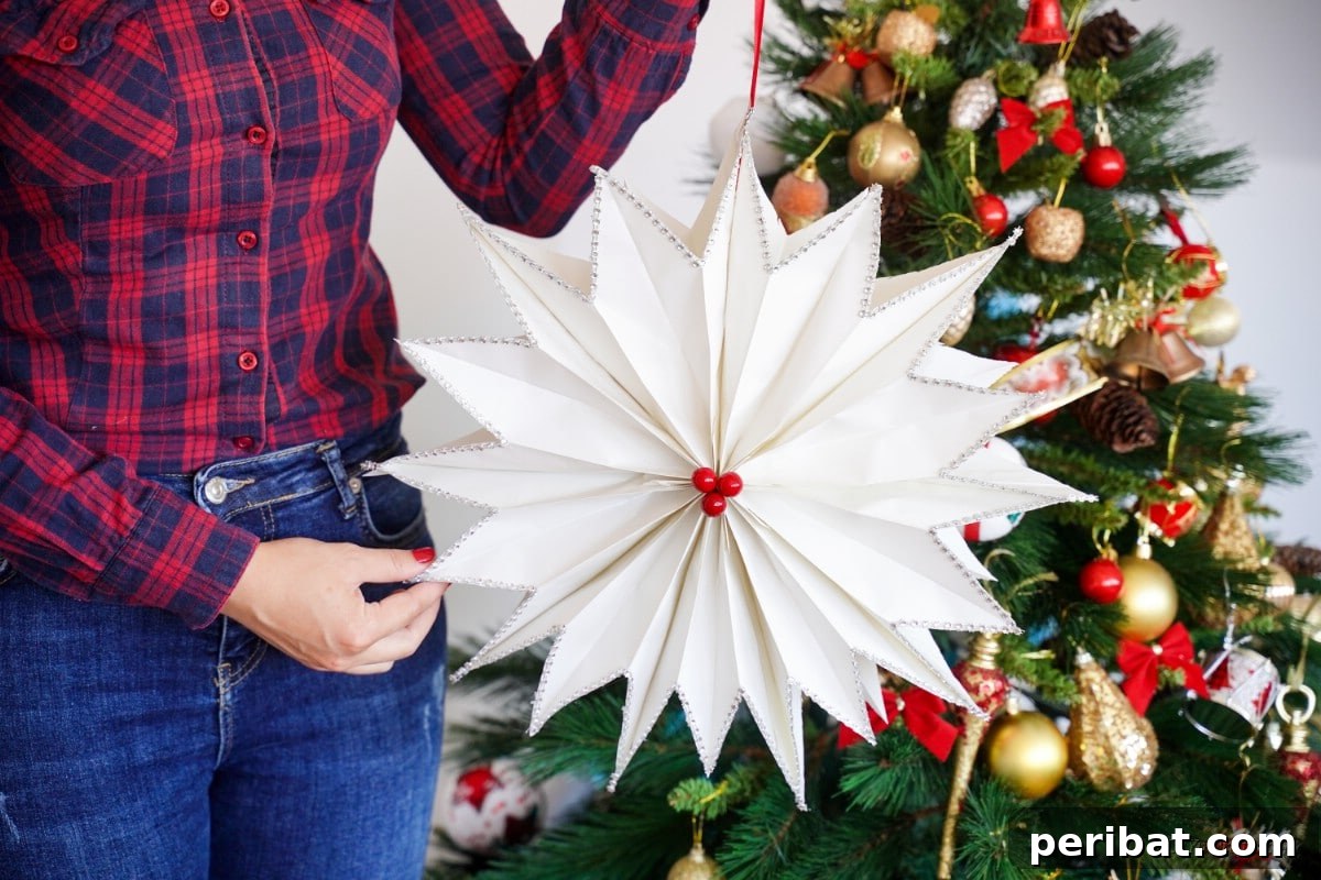 DIY Giant Paper Bag Star Decorations 3 Giant star made from white paper being held by person, showing intricate folds