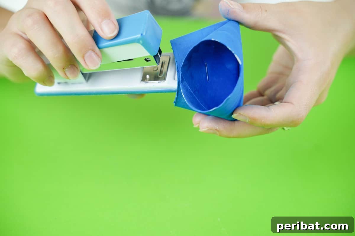 Roll-Upcycled Christmas Cheer 11 stapled toilet paper roll with blue paint