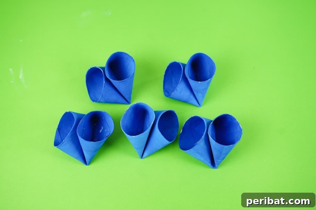 Roll-Upcycled Christmas Cheer 12 folded blue toilet paper rolls on table