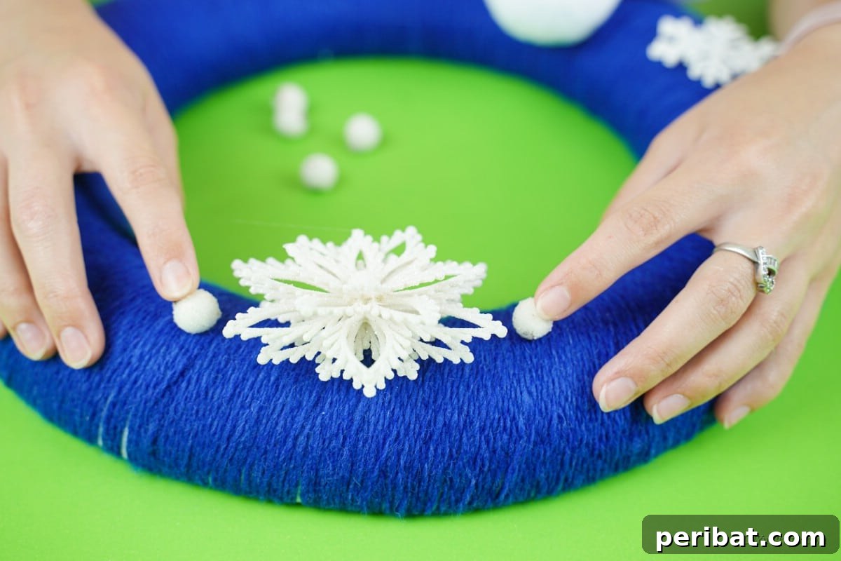 Glistening Snowflake Christmas Wreath 12 Beautiful snowflake decorations being carefully applied to the blue wreath, enhancing its winter theme