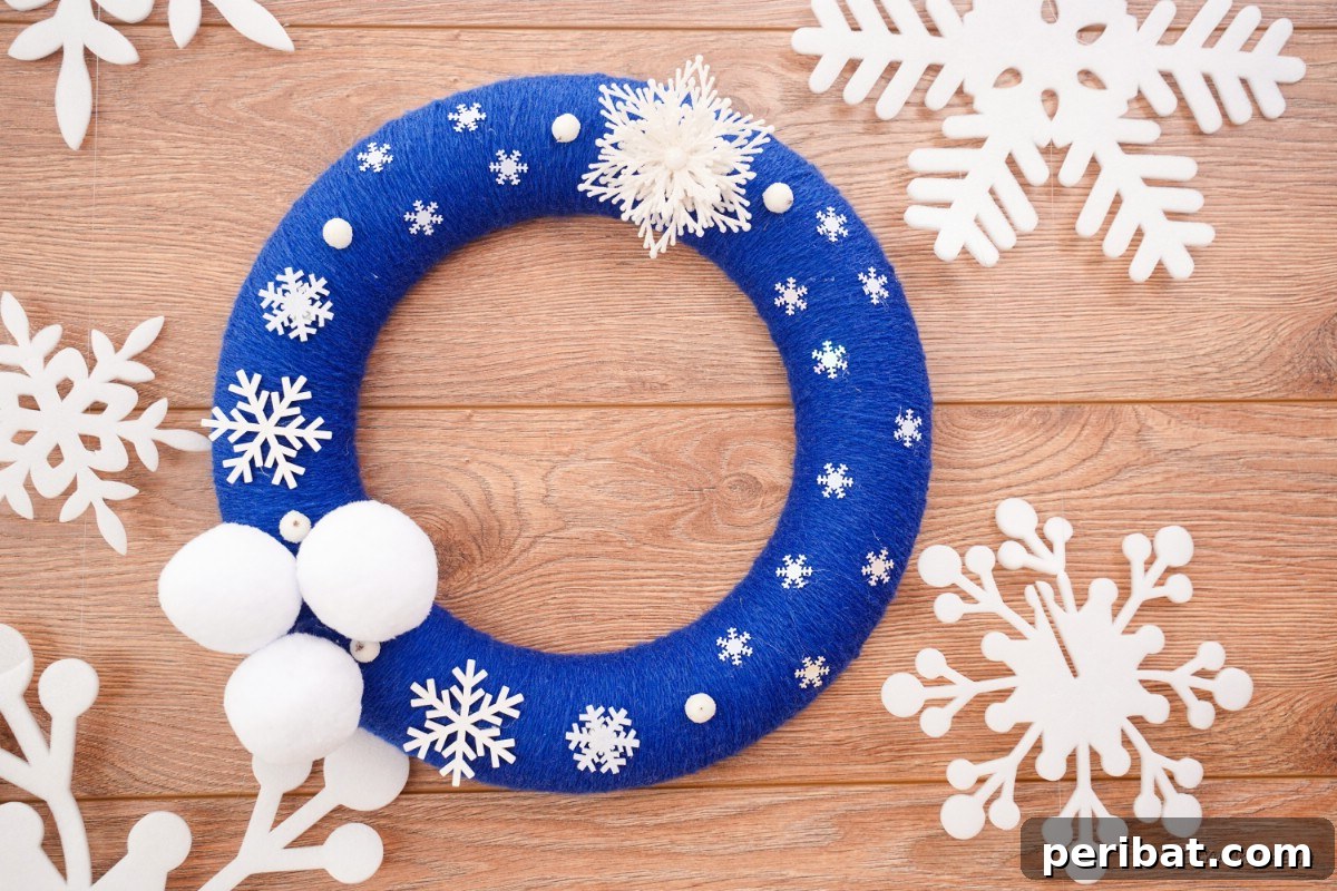 Glistening Snowflake Christmas Wreath 4 Close-up of a blue winter wreath form with white snowflake embellishments, highlighting texture and design