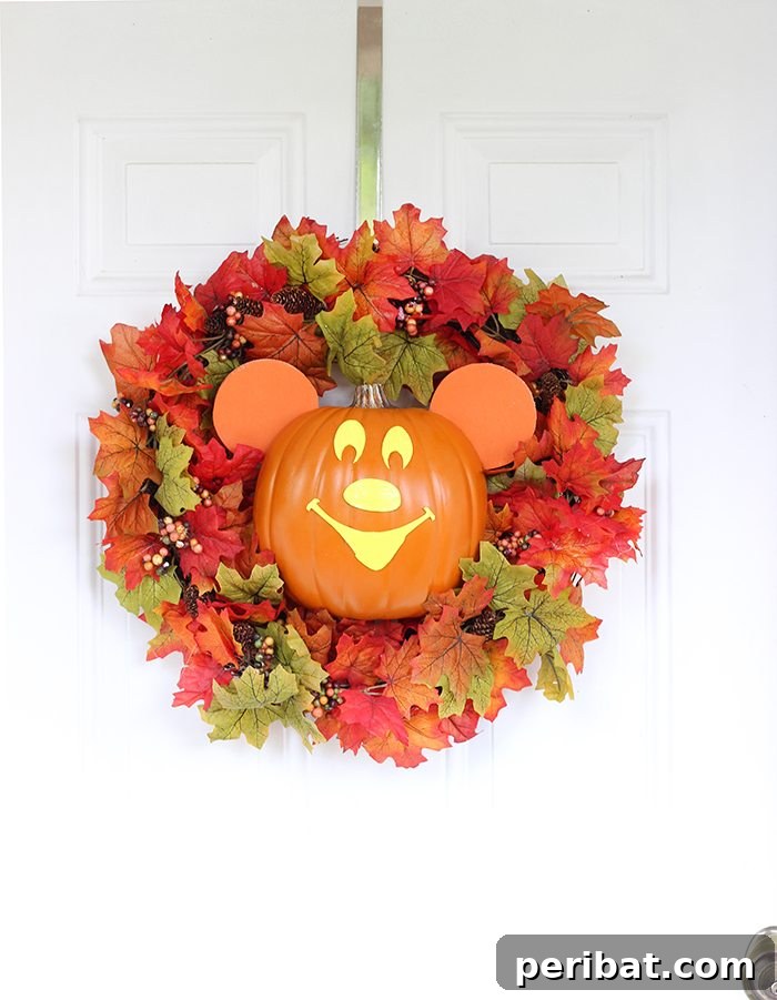 55+ Creative DIY Pumpkin Decorating Ideas for Fall 32 A charming Mickey Mouse pumpkin wreath displayed on a white door for Halloween