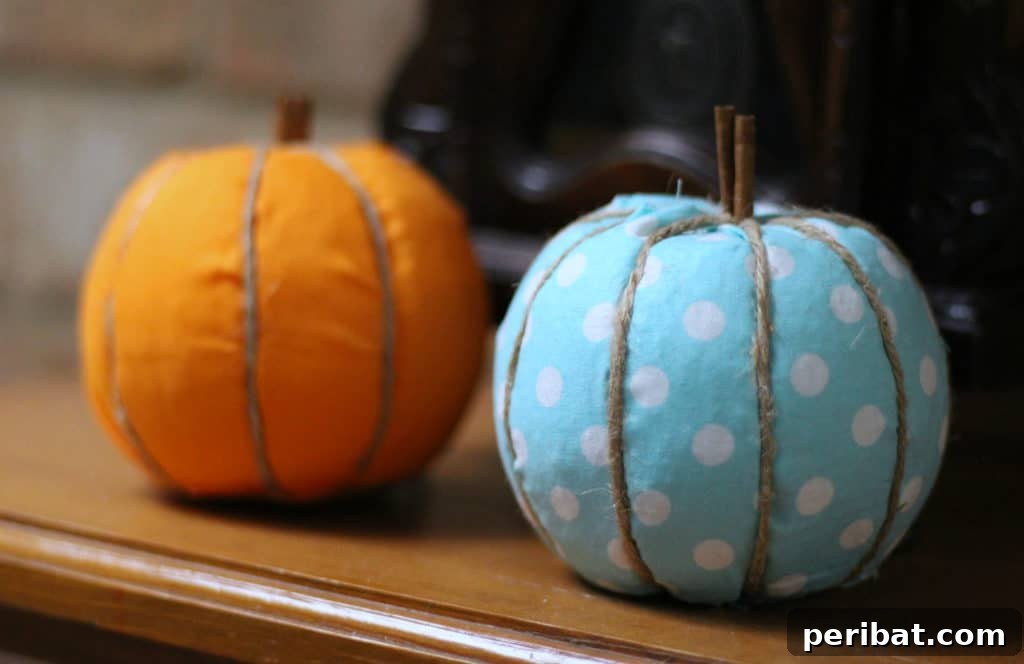 55+ Creative DIY Pumpkin Decorating Ideas for Fall 34 Rustic blue and orange fabric pumpkins with natural stems displayed on a shelf