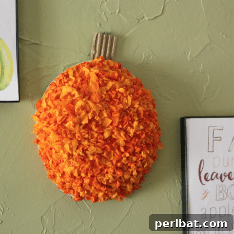 55+ Creative DIY Pumpkin Decorating Ideas for Fall 35 A vibrant tissue paper pumpkin craft displayed on a wall, perfect for kids
