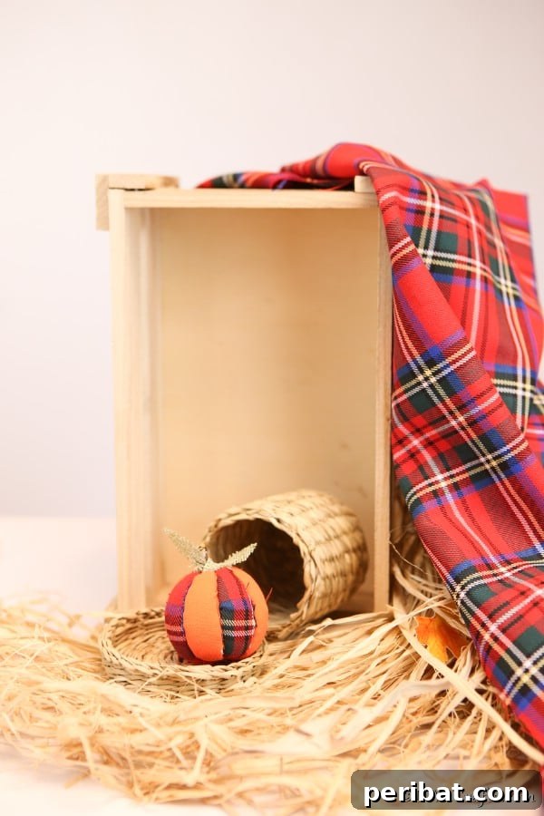 55+ Creative DIY Pumpkin Decorating Ideas for Fall 6 A charming fabric pumpkin ornament displayed on hay inside a rustic wooden box for Fall