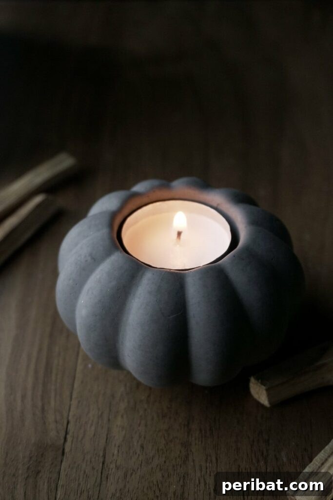 55+ Creative DIY Pumpkin Decorating Ideas for Fall 57 A rustic concrete pumpkin serving as a candle holder, illuminated with a lit candle