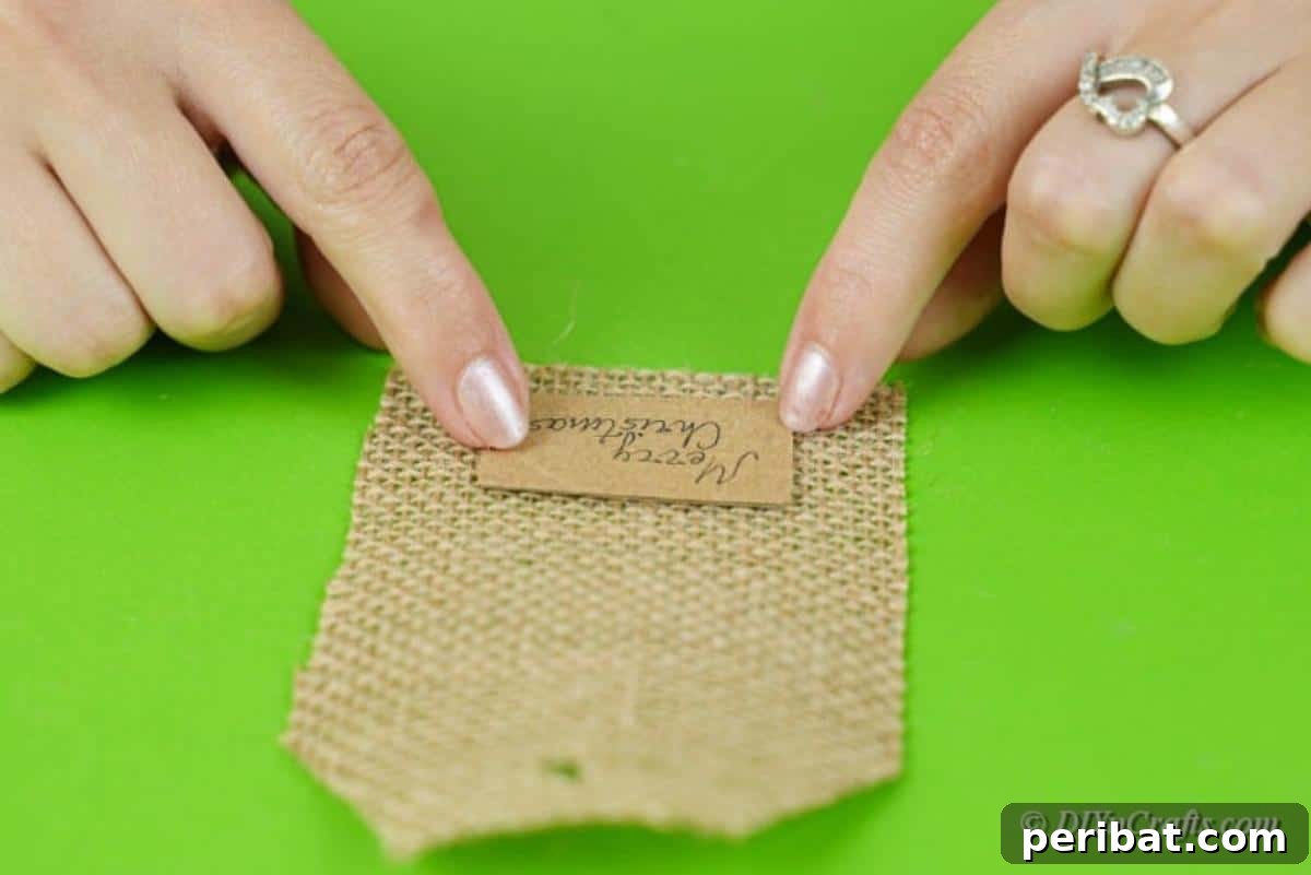 Charming Burlap Christmas Gift Tags: 3 Effortless DIY Styles 13 Applying a decorative felt piece onto a burlap tag using hot glue, demonstrating the embellishment process.