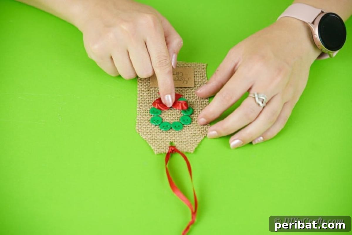 Charming Burlap Christmas Gift Tags: 3 Effortless DIY Styles 15 Process of adding intricate details to a wreath design crafted on a burlap tag, using small embellishments.