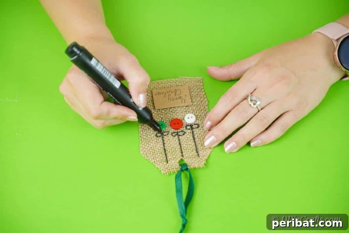 Charming Burlap Christmas Gift Tags: 3 Effortless DIY Styles 16 Crafter adding fine details to burlap gift tags with a marker, showcasing the intricate finishing touches.