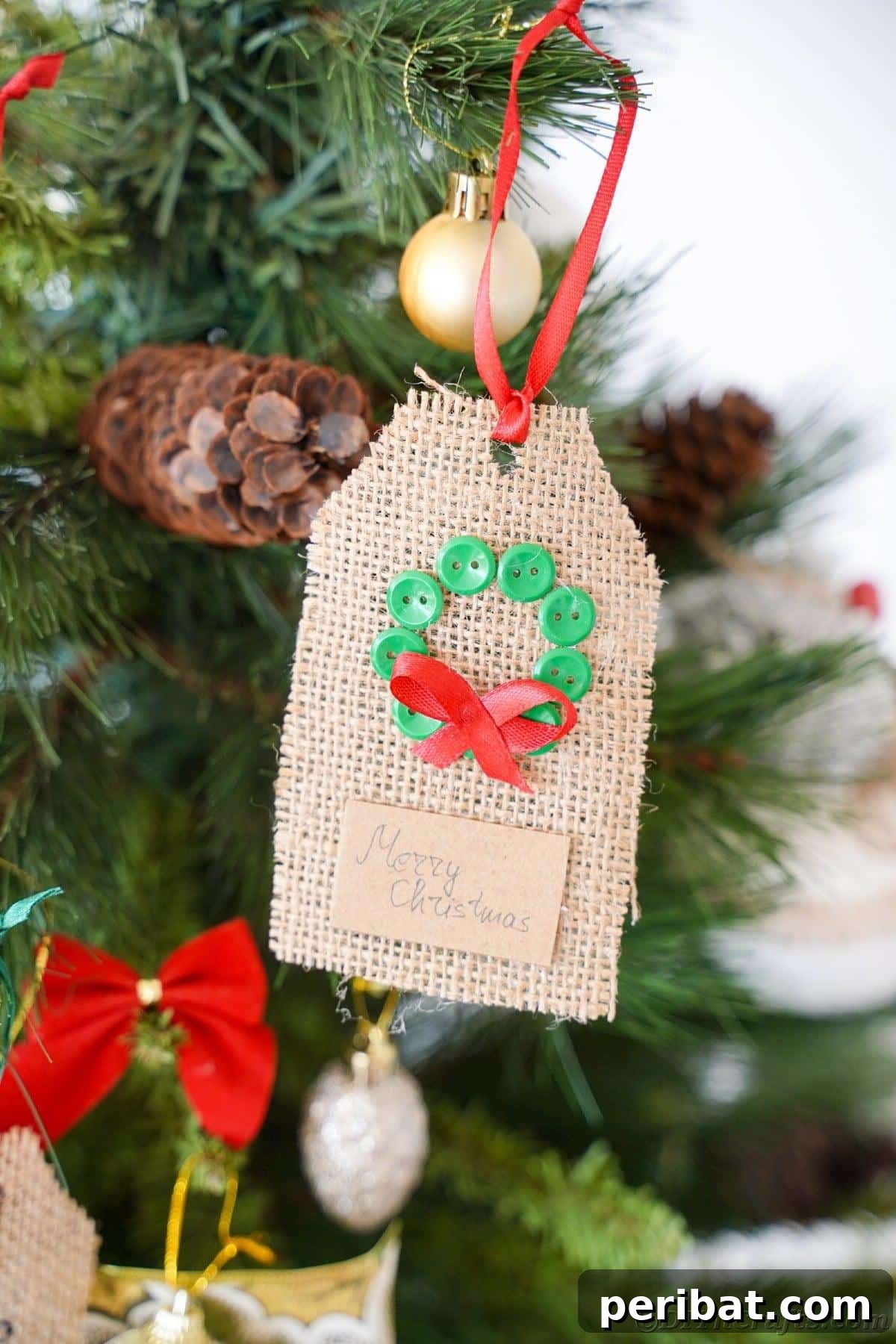 Charming Burlap Christmas Gift Tags: 3 Effortless DIY Styles 27 A festive wreath-themed gift tag crafted from burlap, gracefully hanging as an ornament on a beautifully decorated Christmas tree.
