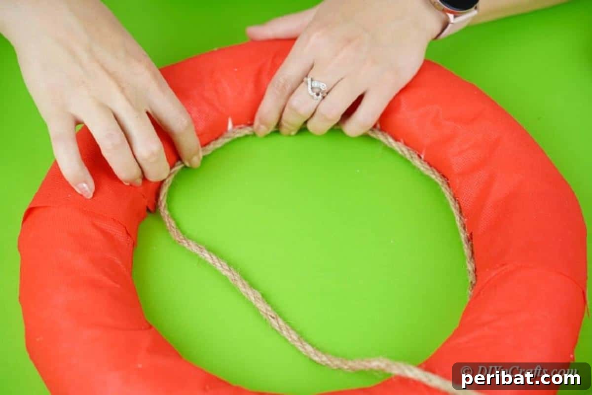 Attaching twine to the top of the wrapped wreath