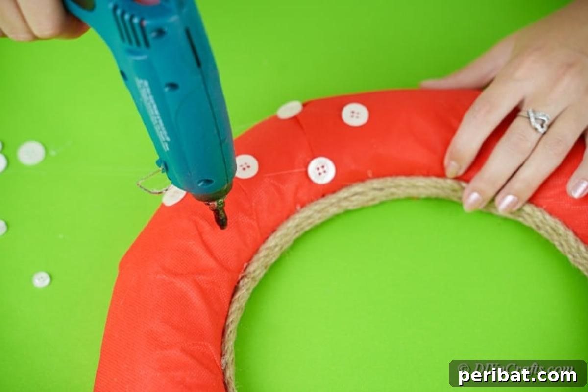 Carefully gluing white buttons onto the wreath form