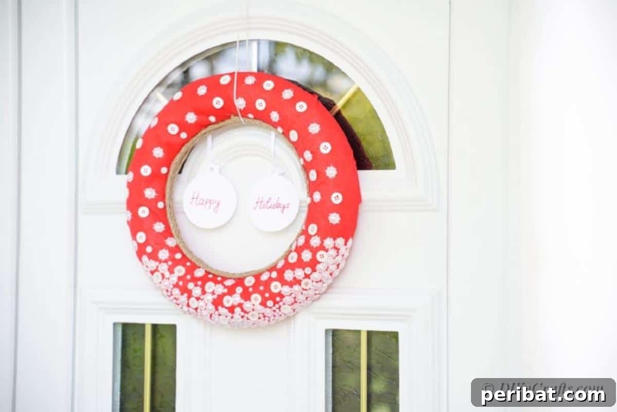 Festive button Christmas wreath displayed on a blue front door