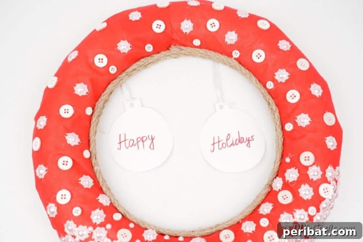Handmade button wreath decorated with white buttons and festive paper ornaments